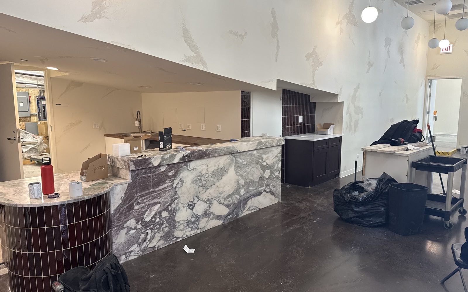 A commercial interior mid build-out, with a stone-clad service counter going in