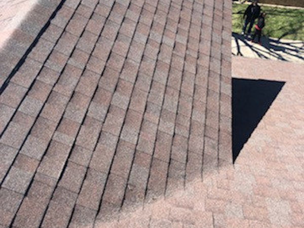 Close view along a hip on the same shingle roof, showing the courses meeting at the hip line