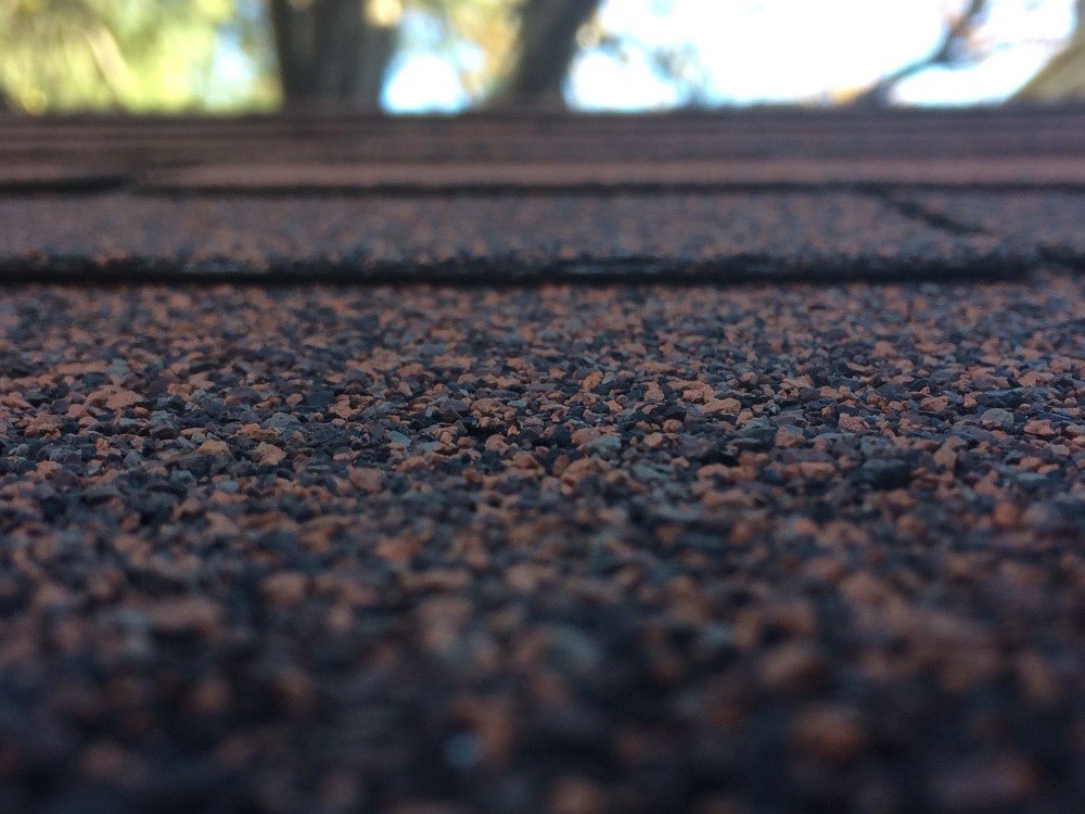 Close-up of asphalt shingle granules in brown and charcoal